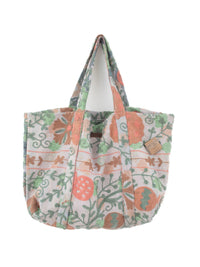 Pastelfarvet, blomsterprintet quiltet tote-taske med grønt og ferskenfarvet botanisk print på hvid baggrund